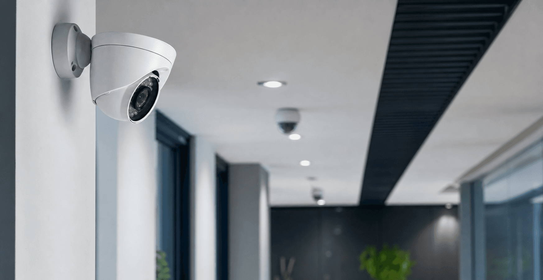 Camera de videosurveillance professionnelle installee dans un couloir d'entreprise.